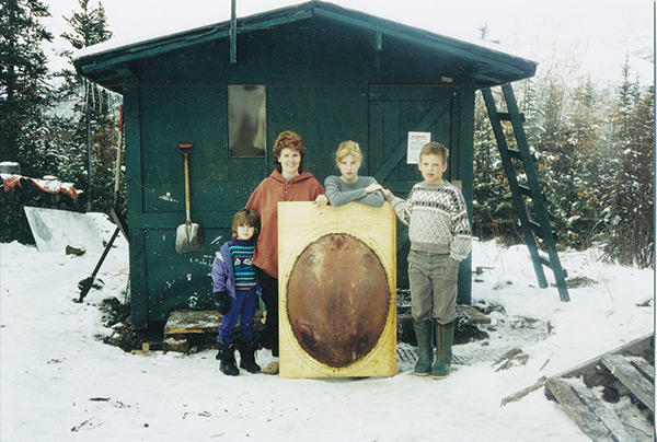 O'Farrell family with small cabin and beaver pelt